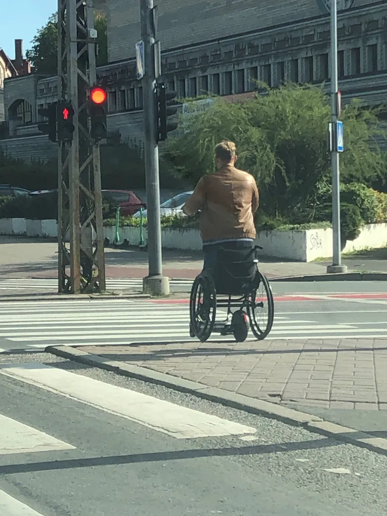 Ratastoolis mees elektritõukerattaga sõitmas.