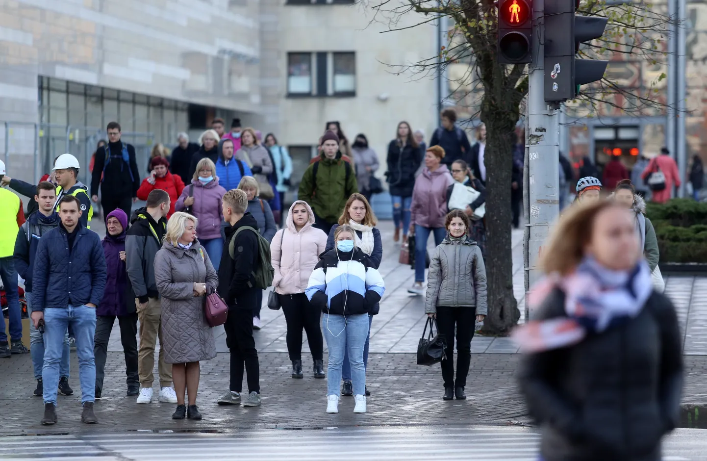 CIlvēki pie gājēju pārejas Stacijas laukumā.