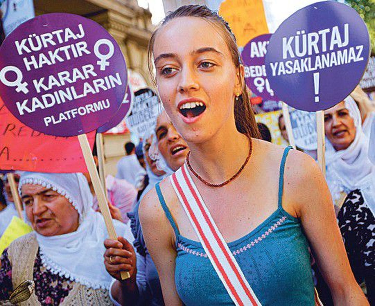 В Стамбуле можно увидеть женщин как в хиджабах, так и в открытых топиках: на снимке слева женщины протестуют против ограничения права на аборт, справа — возмущаются действиями Израиля.
