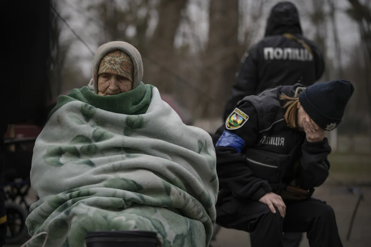 Офицер украинской полиции не может сдержать эмоций после того, как пришлось утешать людей, эвакуированных из Ирпеня на окраине Киева. Украина, 26 марта 2022. ФОТО: Вадим Гирда / The Associated Press / Scanpix