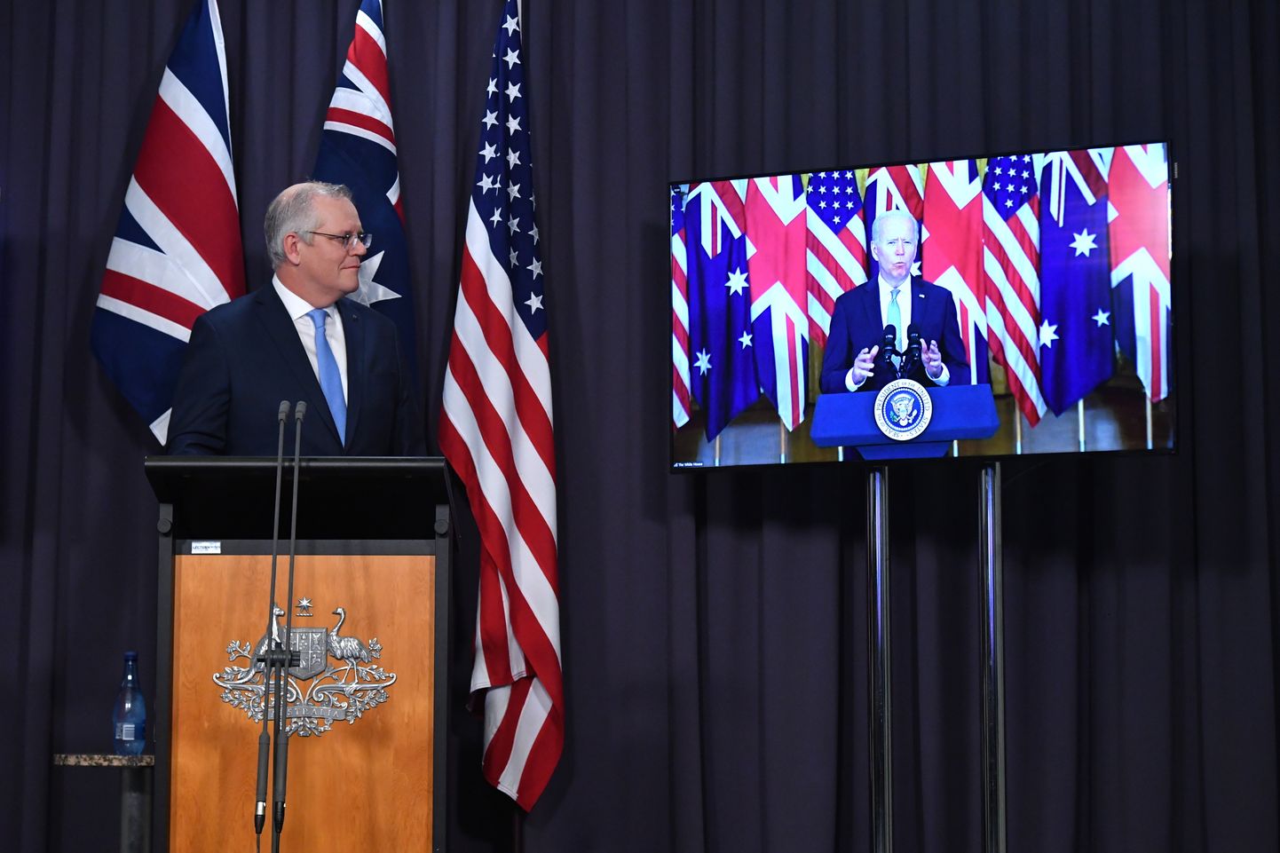 Austraalia peaminister Scott Morrison osales video teel  trilateraalsel julgeolekunõupidamisel ja sellele järgnenud pressikonverentsil. Paremal on näha videot USA presidendi Joe Bideniga
