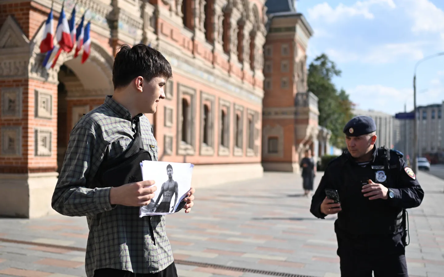 Сотрудник полиции пытается понять участника митинга в поддержку основателя Telegram Павла Дурова возле посольства Франции в Москве, Россия.