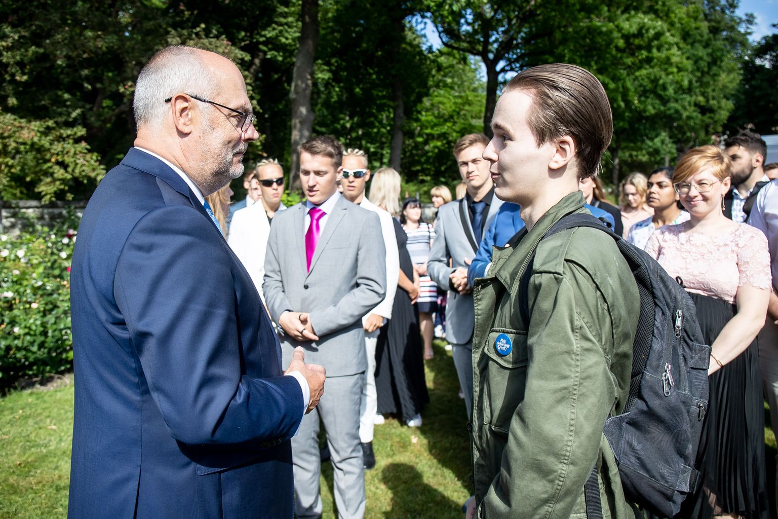 President Alar Karis roosiaia vastuvõtul rääkimas värske Tartu Rakenduslik Kolledži vilistlase Daniliga.