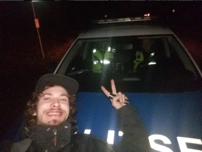 Kalvi-Kalle julgelt politseiauto ees poseerimas.