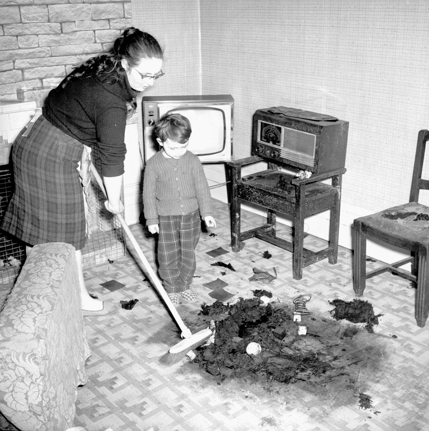 The Peckham Poltergeist strikes again! Mrs Vera Stringer cleans up after the visit from their pyromaniac poltergeist.
10th April 1962