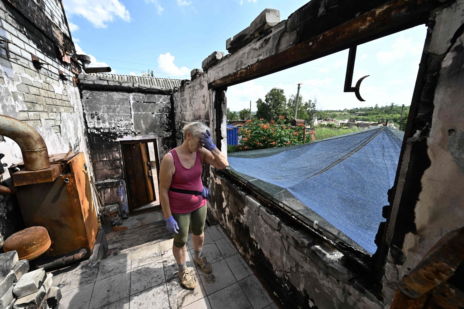 Galõna puhastamas oma tugevasti kahjustatud maja prahist Mala Rogani külas Harkivi oblastis. 2,7 miljoni elanikuga Harkivi oblastis on 90 protsenti elamutest okupatsioonist vabastatud aladel hävinud.