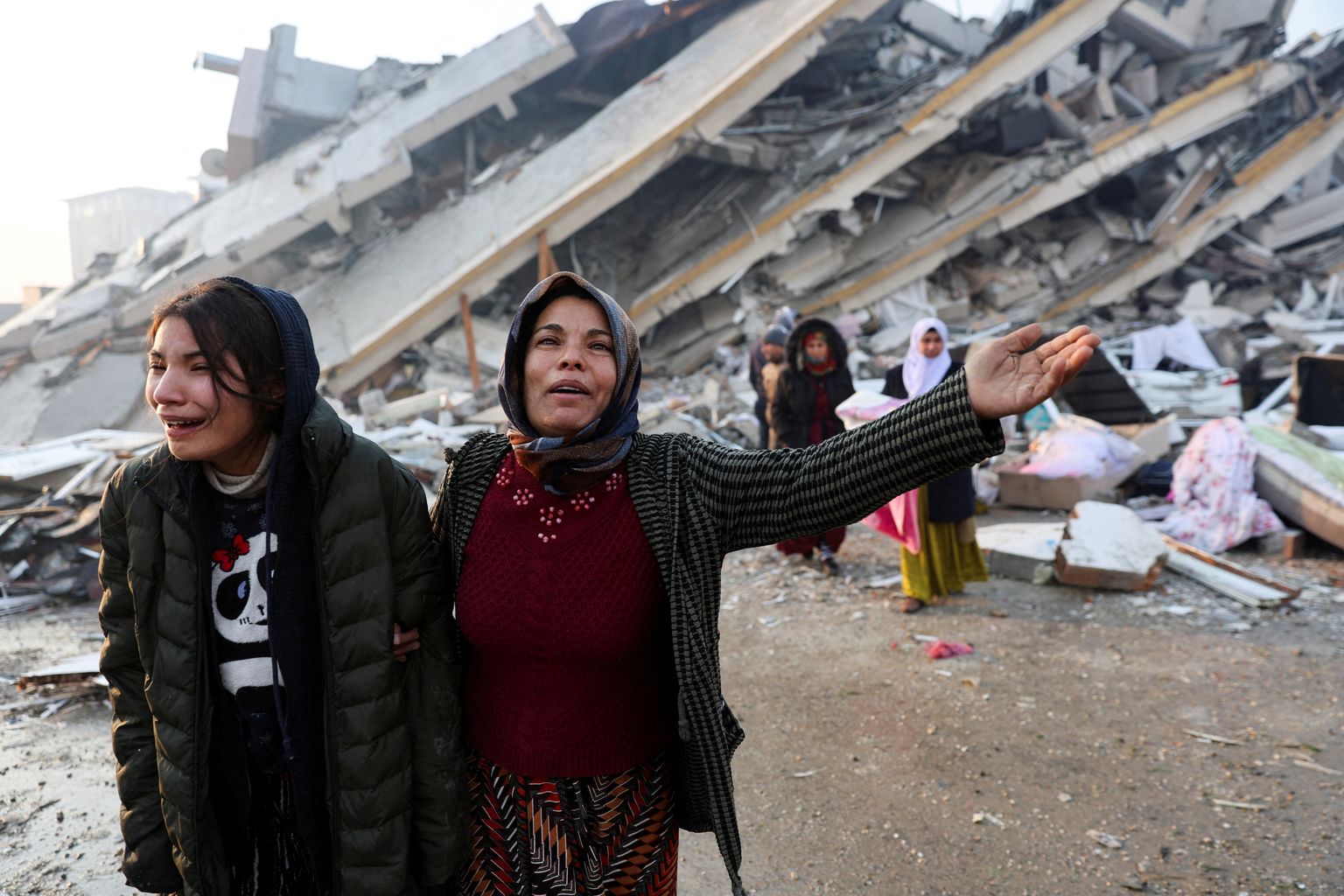 Ahastuses türklannad maavärinas hävinud elumaja ees.