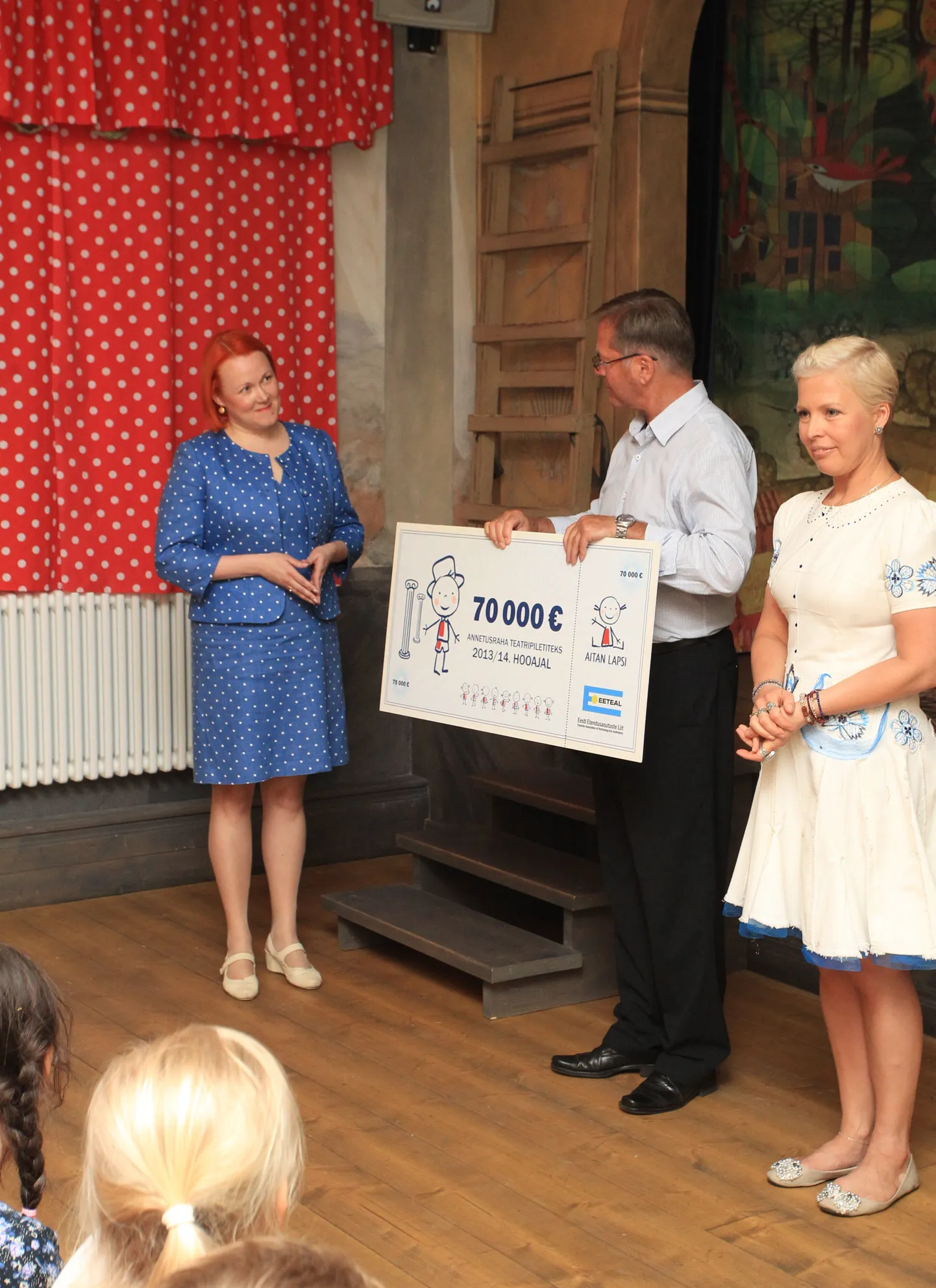 Aitan Lapsi SA juhatuse esimees Paal Aschjem ja patroon Evelin Ilves andsid Eesti Etendusasutuste Liidu tegevjuhi Monika Larinile üle tšeki, et pakkuda vähekindlustatud lastele teatrielamusi.
