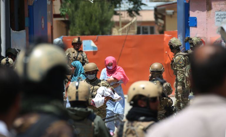 Afganistani julgeolekujõud ja rünnakus ellu jäänud emad haiglast lapsi välja toomas.