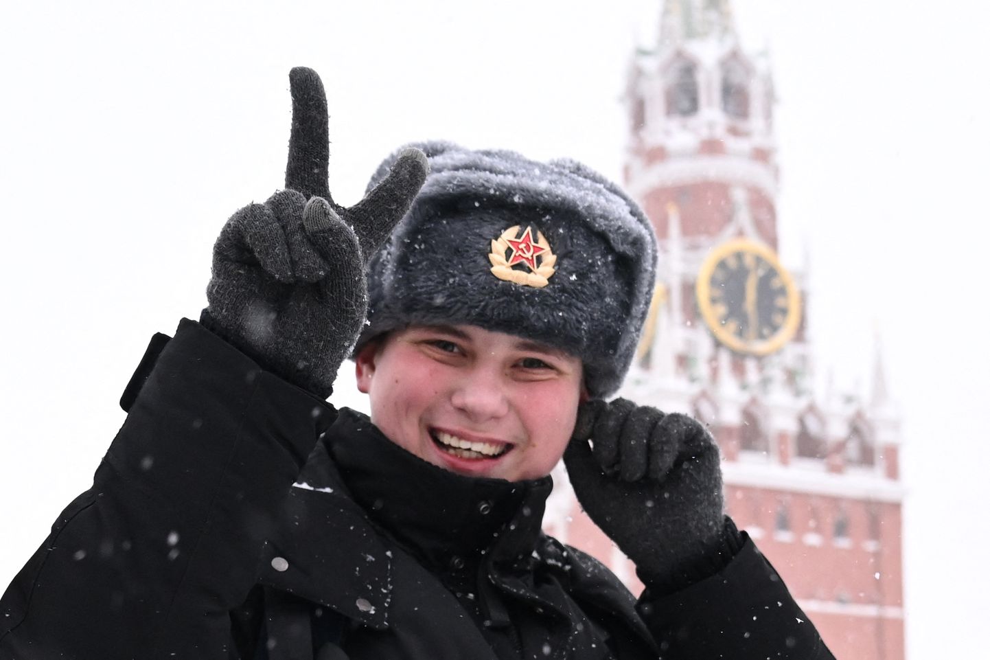 Punaarmee mütsis mees näitab Moskva Punasel väljakul võidumärki.