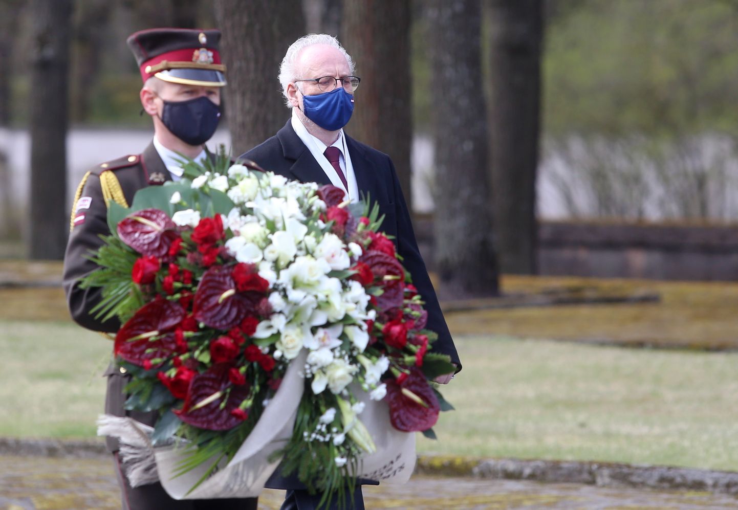 Valsts prezidents Egils Levits (no labās) noliek vainagu Rīgas Brāļu kapos,godinot nacisma sagrāves un Otrā pasaules kara upuru piemiņu