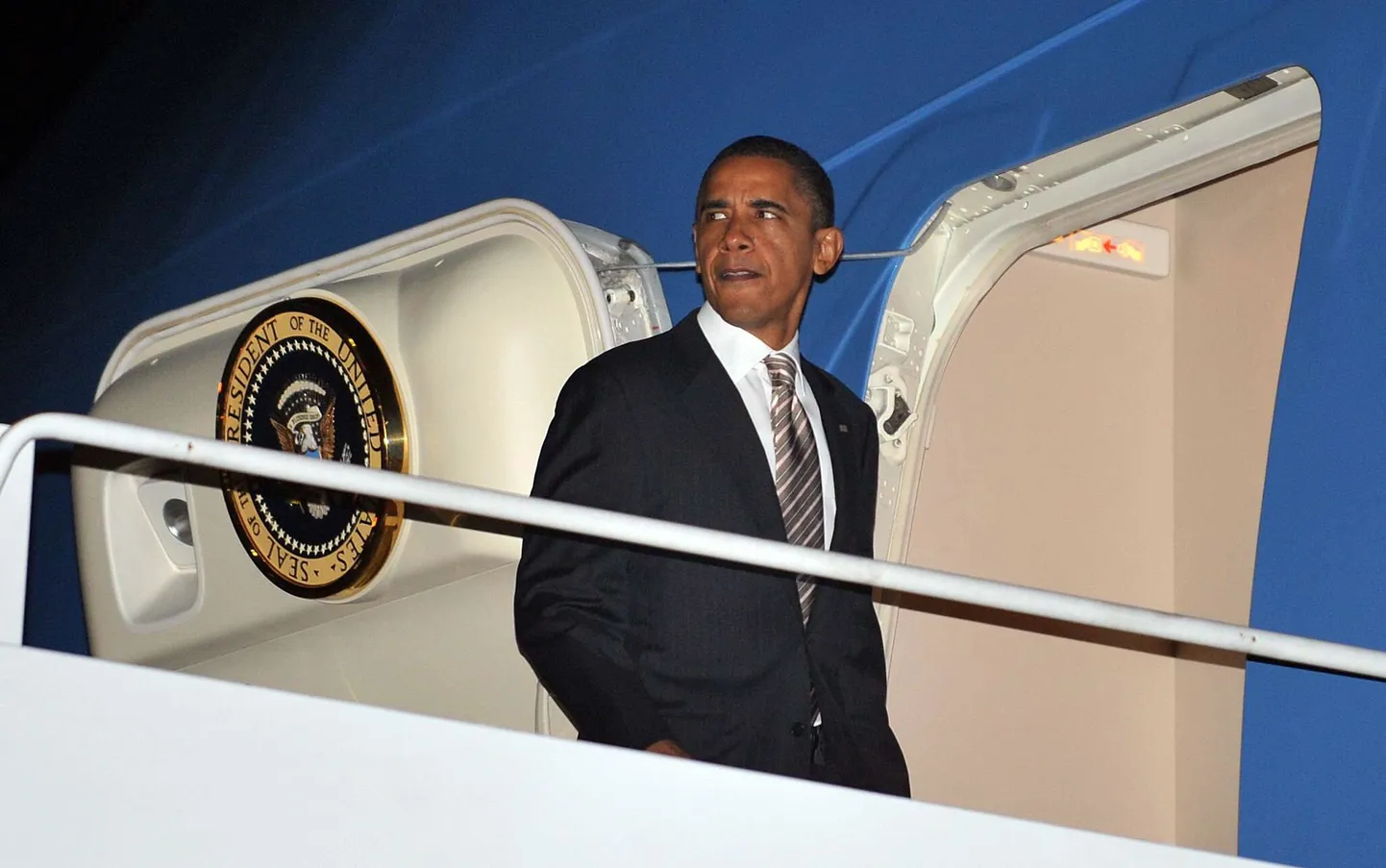 Барак Обама спускается по трапу своего самолета.