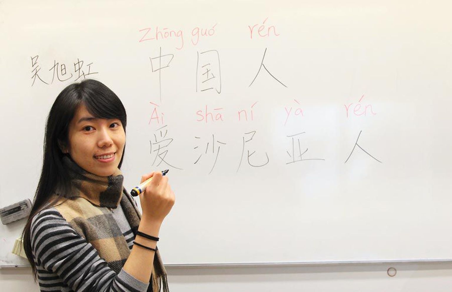 Õpetaja Wu Xuhong kirjutas tahvlile sõnad «Hiina inimesed» ning «Eesti inimesed».