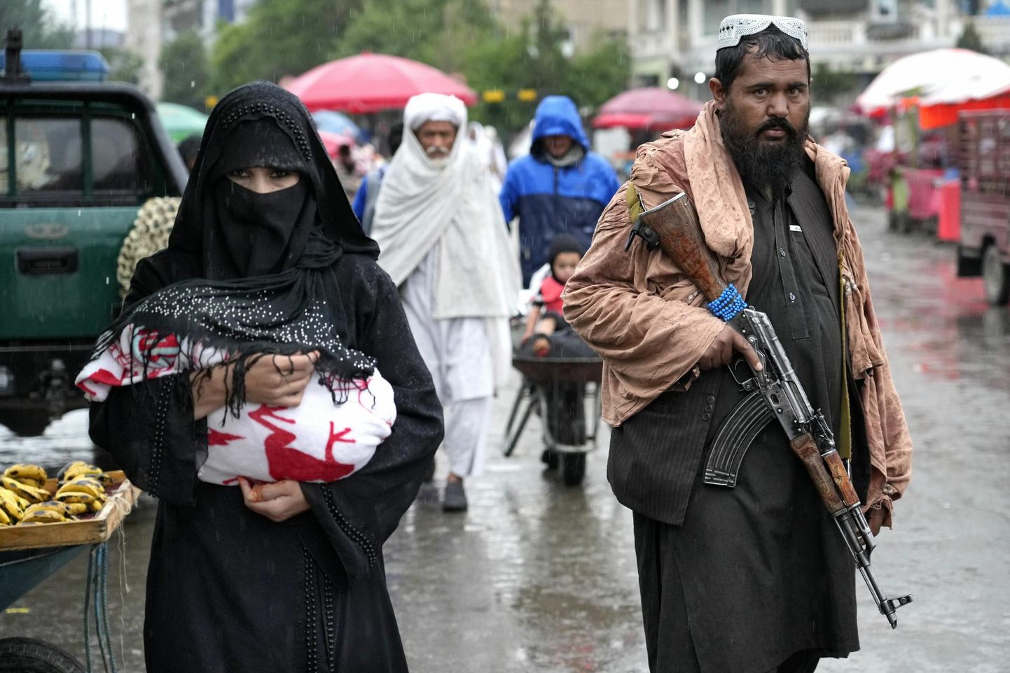 Afgaani naine kõnnib Kabuli turul, kuid teda saadab Talibani võitleja. 