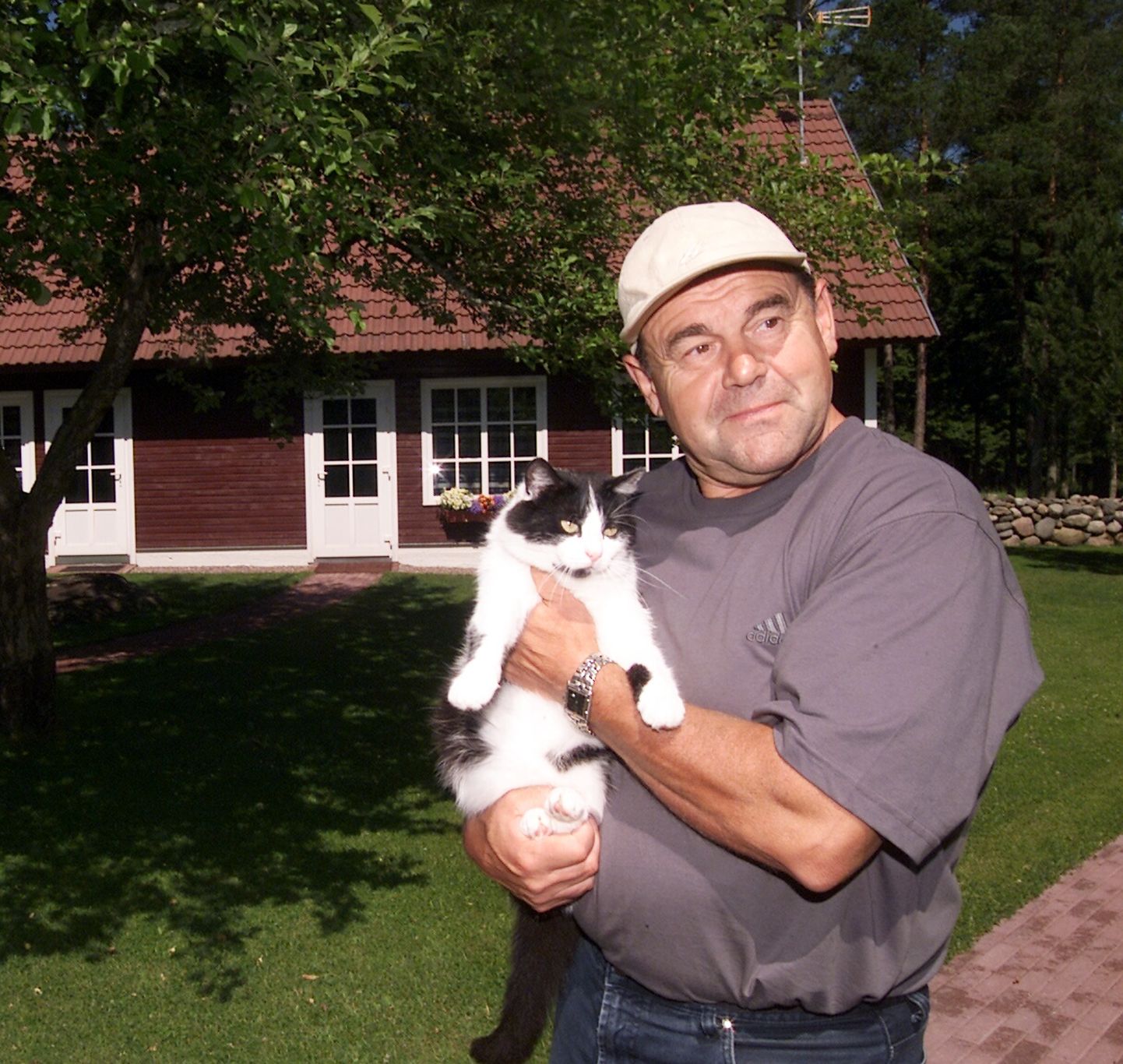Jaan Talts oma kodutalus koos kass Kissaga õues.