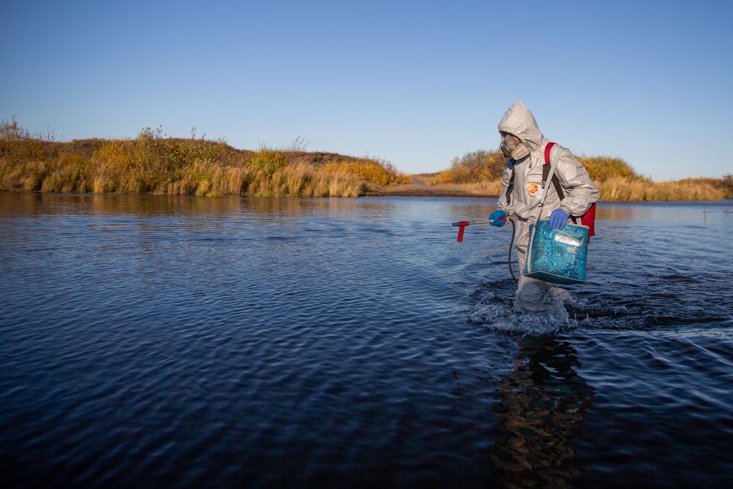 Эксперт Greenpeace берет пробы загрязненной воды.