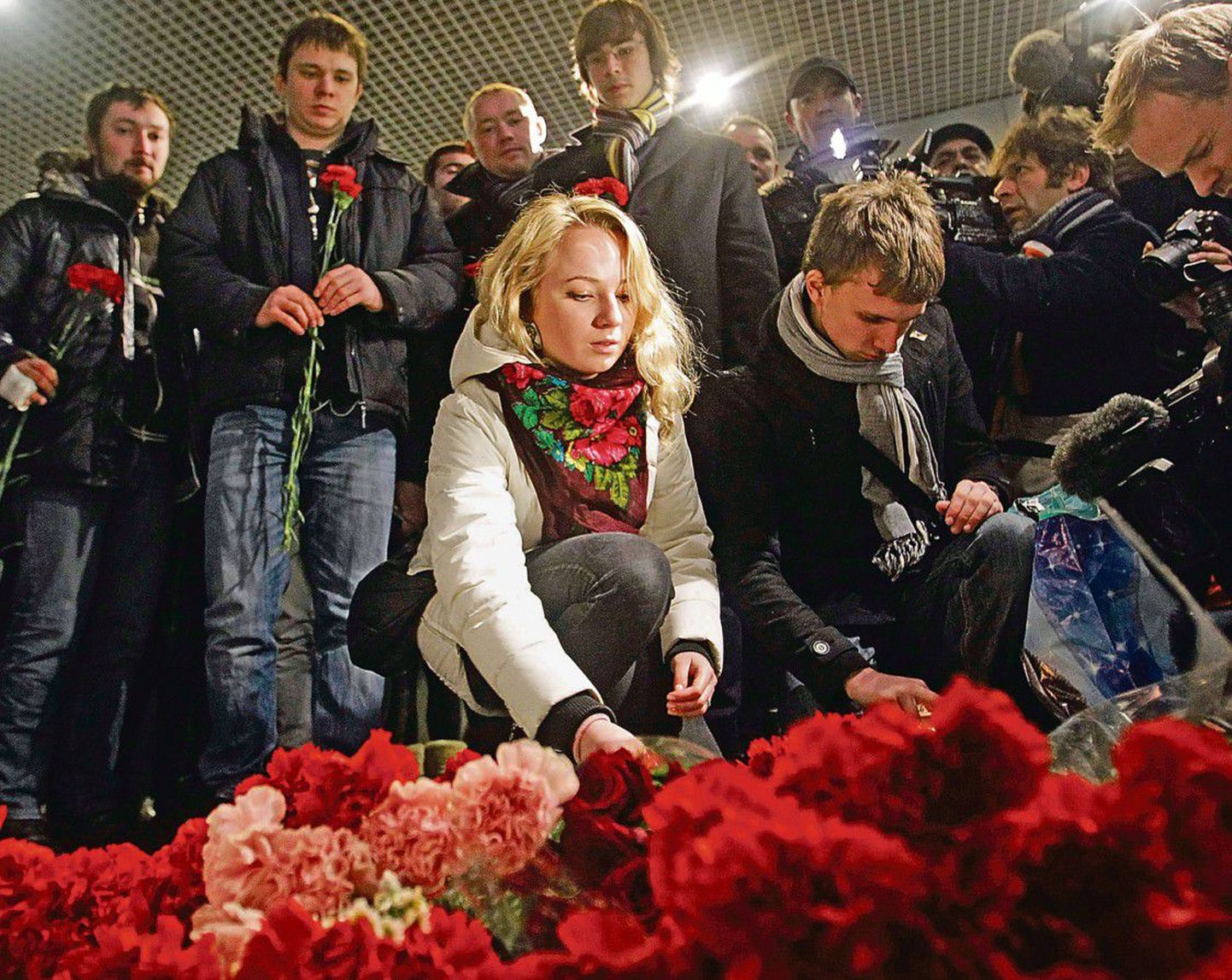 Люди возлагают цветы в аэропорту «Домодедово» после трагедии.