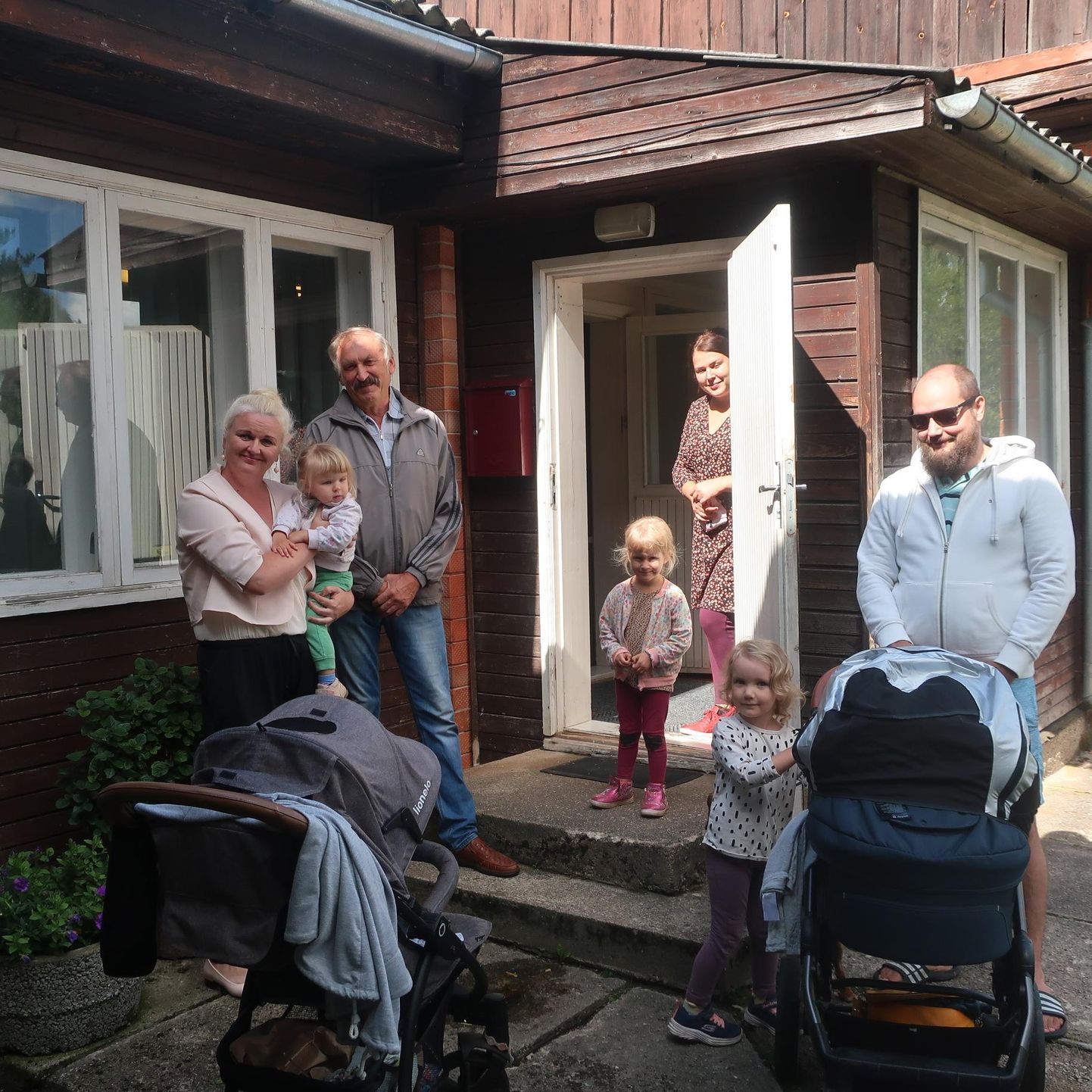 Leevaku raamatukogu uksel kohtusid kolmapäeval Räpina vallavanem Enel Liin (vasakult), külavanem Vello Kasearu, küla elanik Kristiina Hüvato (uksel), tallinlane Priit Kaup ning lapsed.