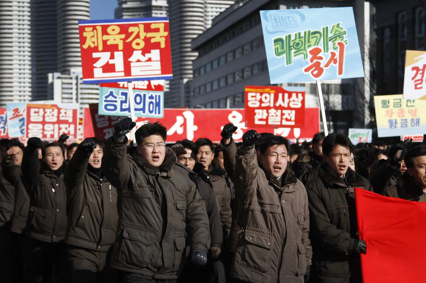 Põhja-Korea plakatid kuulutavad spordi, teaduse ja songuni poliitika arendamist.