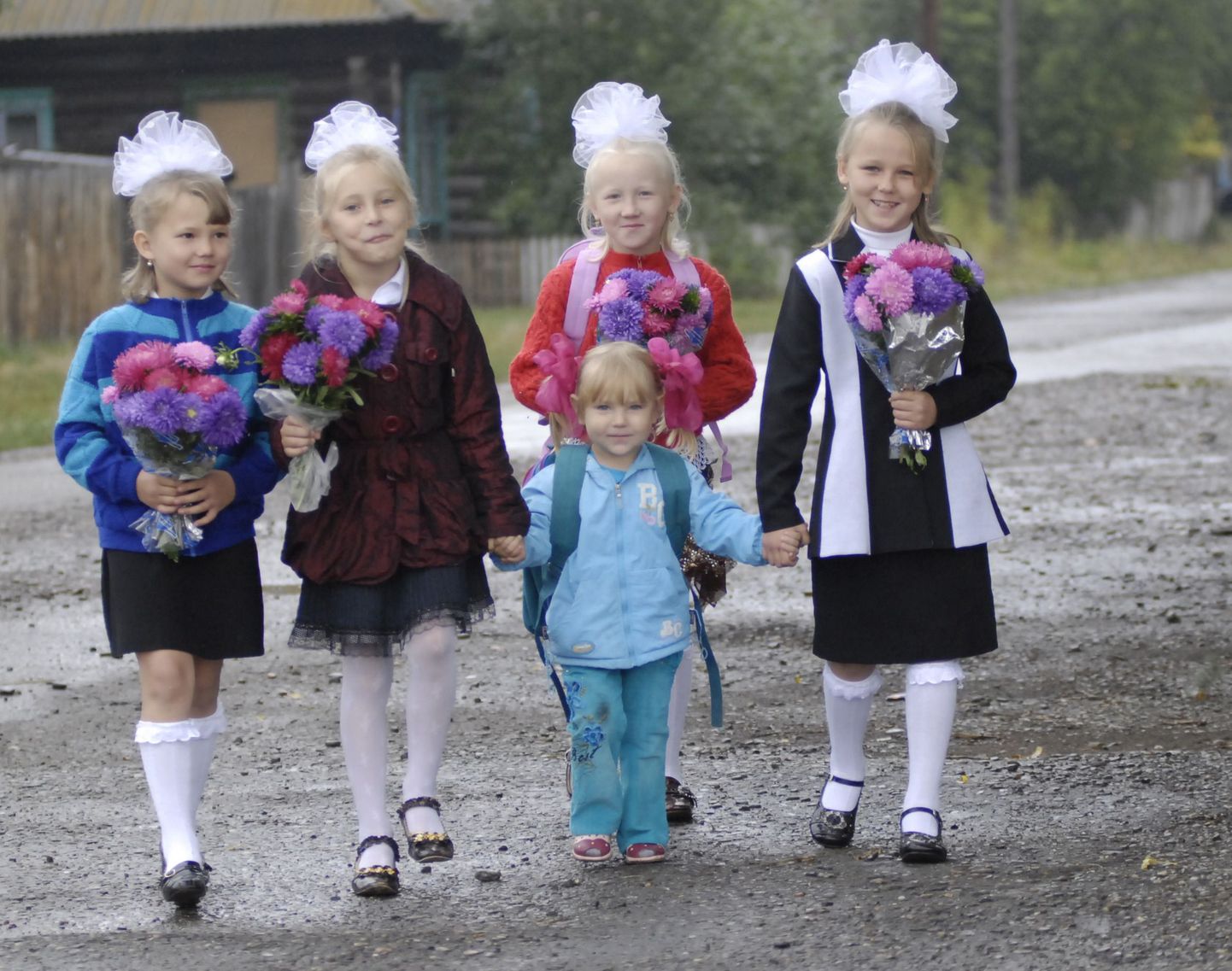 Väikesed vene tüdrukud suunduvad esimese koolipäeva aktusele.