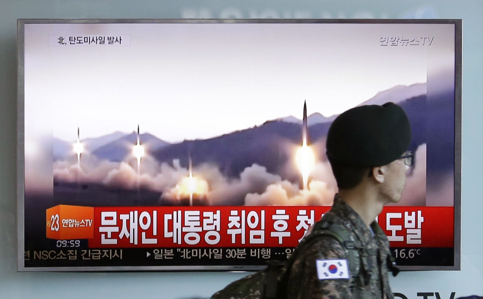 Lõuna-Korea sõdur möödumas televiisorist, kus näidatakse pilti Põhja-Korea raketikatsetusest.