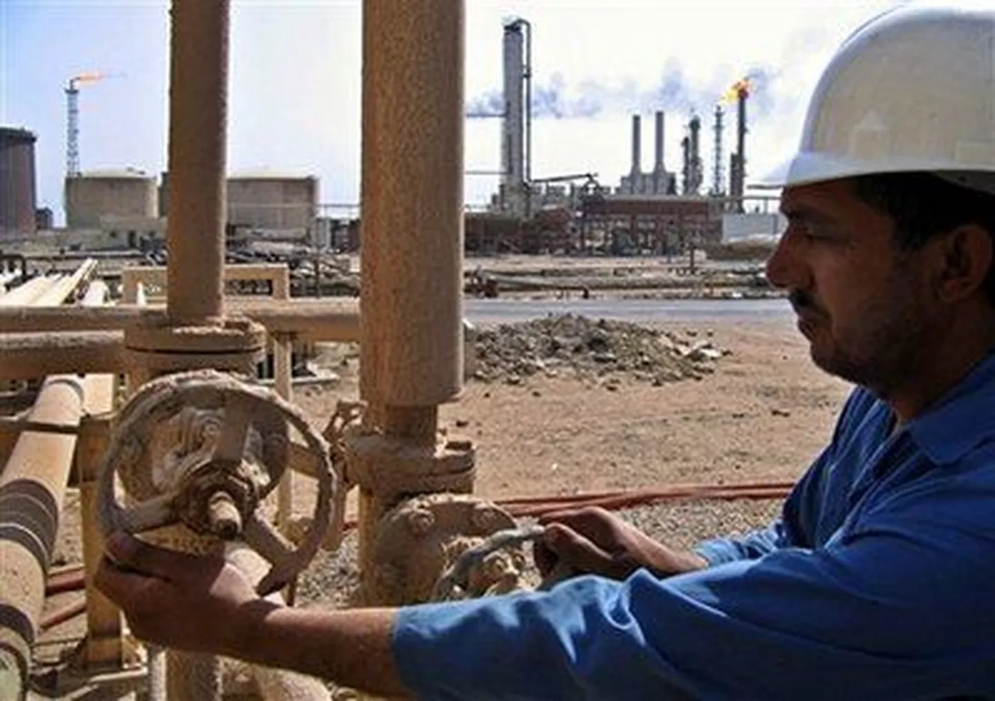 Iraaklasest tööline keeramas kraani Rumaila naftaväljadel.